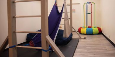 Children using monkey bars and climbing equipment in sensory gym